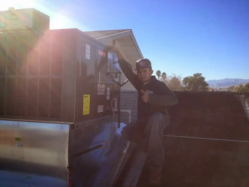 HVAC technician performing AC Tune-Up on a rooftop unit in Lemon Grove